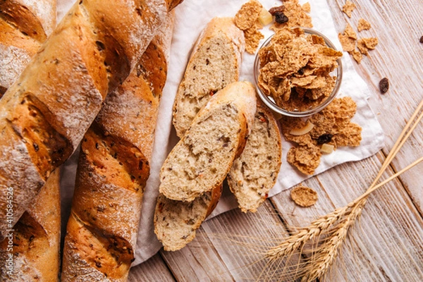 Fototapeta Top view on cereal baguette loafs on the wooden decorated background
