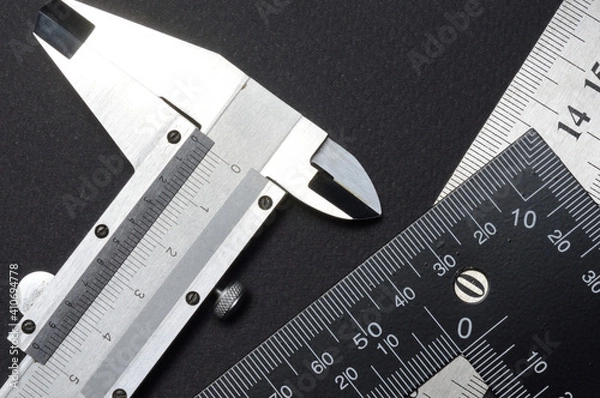 Fototapeta measuring tool, ruler square and caliper. lie on a dark background. close-up.
