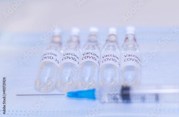 Obraz ampoules with Covid-19 vaccine on a laboratory on the table, syringe