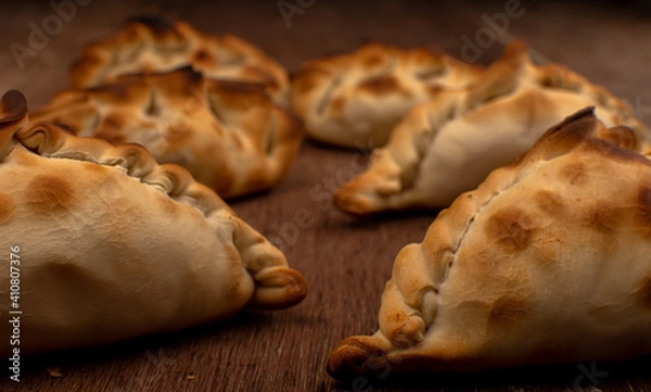 Fototapeta Traditional Argentinean empanadas pie on table, meat Chicken and vegetables