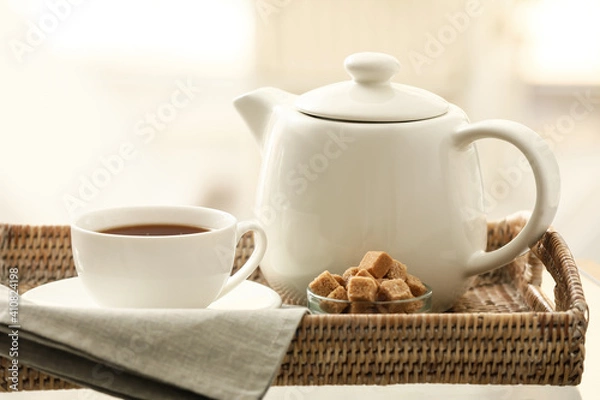 Fototapeta Teapot and cup with tea on tray in room