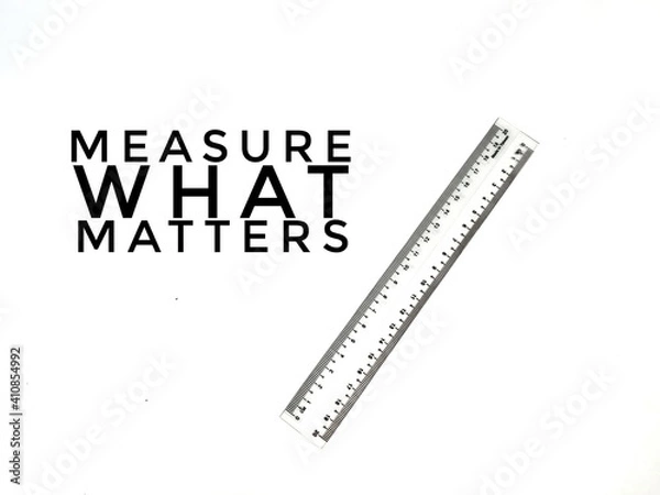 Fototapeta Measure what matters quote with a ruler on white background.