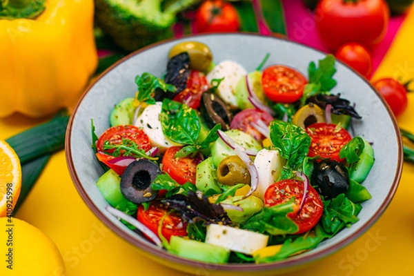 Fototapeta healthy food. Greek Salad with cheese, cucumbers, tomatoes and olives on a decorated table