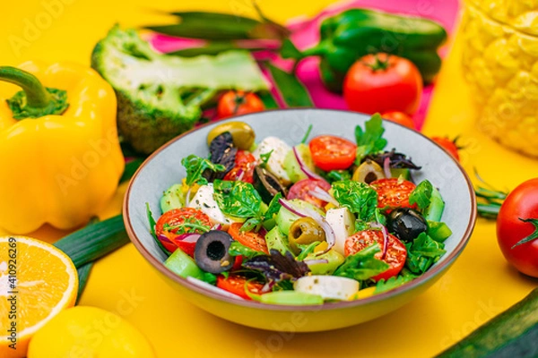 Fototapeta healthy food. Greek Salad with cheese, cucumbers, tomatoes and olives on a decorated table