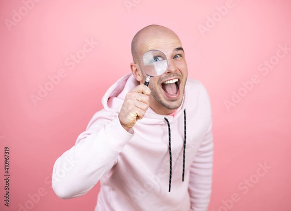 Fototapeta surprised looking through a magnifying glass