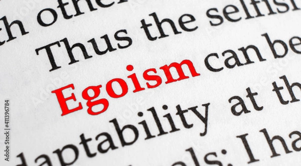 Fototapeta Selective focus on the red word egoism. Macro shot printed red colour word Egoism on a piece of paper.