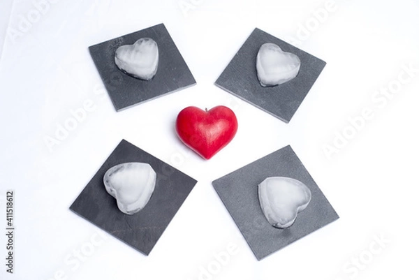 Fototapeta Top view on a red love heart and 4 slate plates with ice hearts on them, on a white background