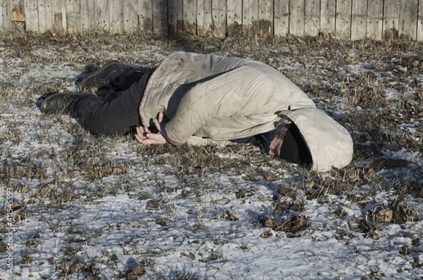 Obraz Murder. The body of a man lies on the melting snow. Brutal crime.