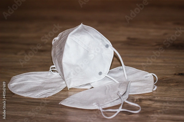 Obraz White respiratory mask N95 FFP2 on a wooden background close-up. Coronavirus Medical Protection Concept. Protective masks. Protection against pollution, virus, flu and corona virus.