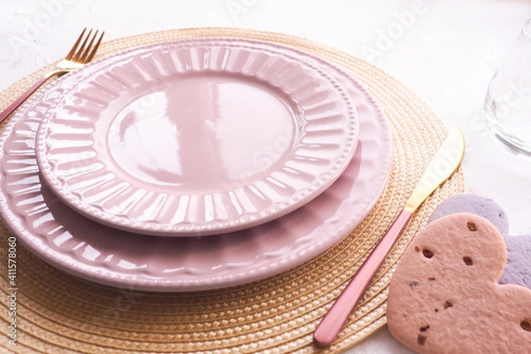 Obraz table setting. two empty pink plates, spoon and fork on a white table. copy space..
