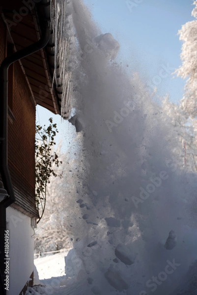 Fototapeta Germany, Scheidegg - January 19, 2021: Workers clean the snow from the roof after a heavy snowfall in Bavaria, in January 2021