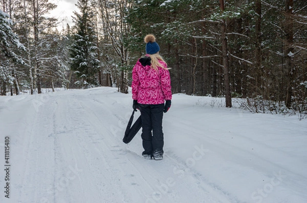 Fototapeta Blonde girl in the forest in winter with a lot of snow, in the forest by car road