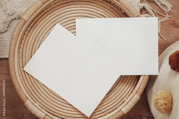Fototapeta White invitation cards in a wooden wicker basket in boho style