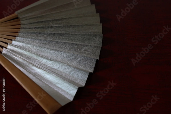 Fototapeta 漆塗り板背景の銀色の扇子