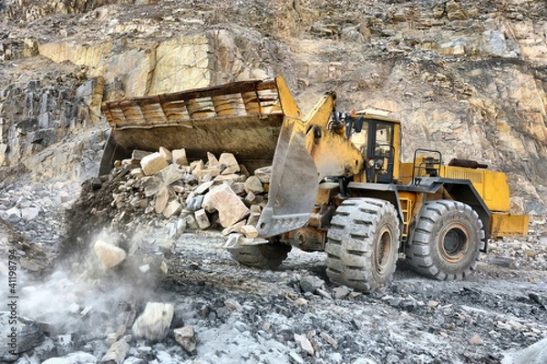 Fototapeta Wheel loader machine unloading rocks