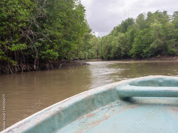 Obraz The blue boat front ran into the mangrove forest. A cloudless sky and the horizon.Space for text.