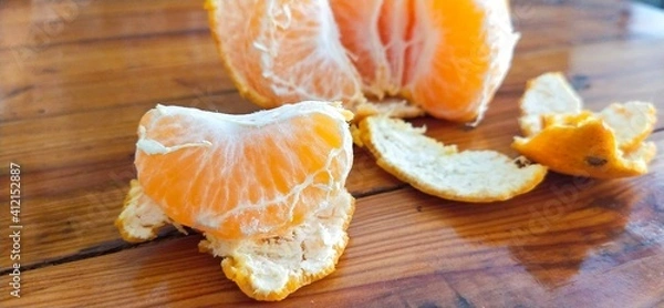 Obraz peeled tangerine on wooden table