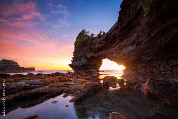 Fototapeta Sunset at Batu Bolong temple and Tanah Lot, Tabanan, Bali. beautiful color with the coral reef in low tide.