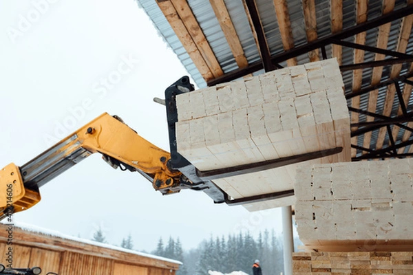 Fototapeta forklift truck with planks, delivery of wood to the warehouse, loading a large number of wooden planks with the help of industrial transport