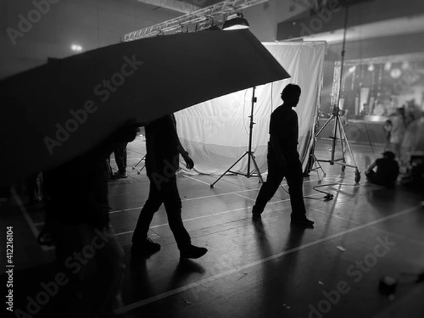 Obraz Behind the scenes of music video shooting production crew team silhouette and camera equipment in studio. Black and White.
