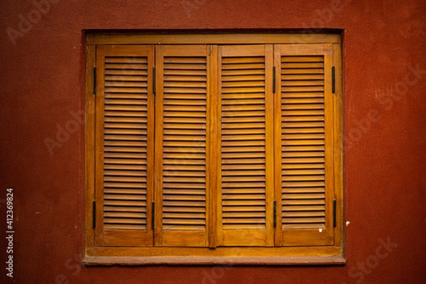 Obraz window with shutters on red wall