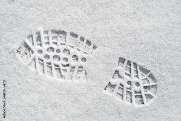 Fototapeta Clearly defined footprint / imprint in fresh snow of rubber lug sole with deep indentations from mountaineering boot / hiking boot in winter