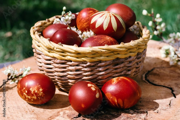 Obraz Basket with easter cake and red eggs on rustic wooden table. Top view.