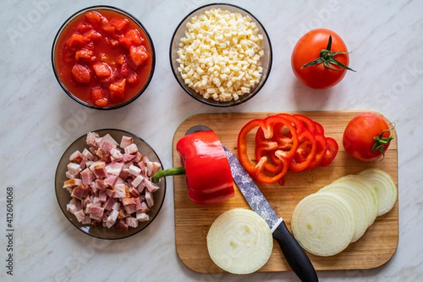 Obraz Home made food concept: top view on cutting board and food like tomatoes, red peppers, bacon and cheese