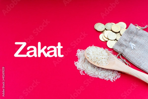 Obraz ZAKAT words with Coins and Rice on red background. Zakat concept. Zakat is a form of alm-giving as a religious obligation