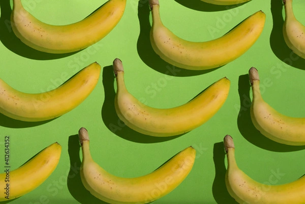 Obraz Creative yellow bananas pattern on green background.