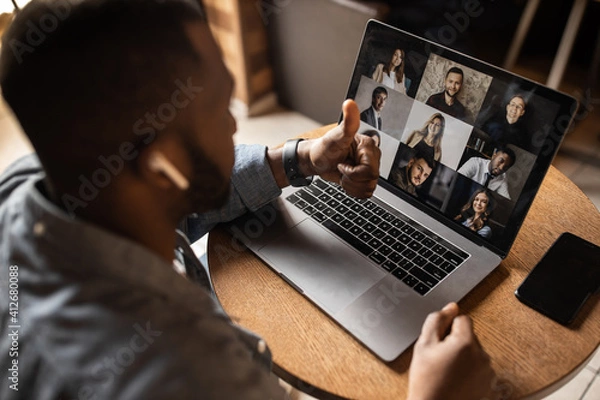Fototapeta Contented African American business man showing thumb up. Leads an online consultation, an excited businessman looks at a laptop screen, a positive customer recommending service, good quality.