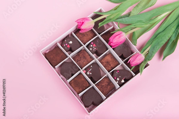 Obraz Present box with chocolate sweets hearts and tulips on pink background. Desert for Valentine Day