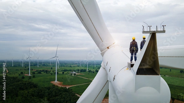 Obraz 
Inspection engineers standing on top of a wind turbine for Background Image.