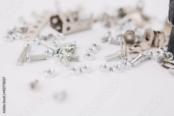 Fototapeta children's iron constructor with nuts and screws and a screwdriver on a white background