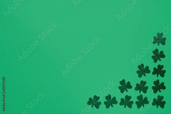Fototapeta Concept of St. Patrick. Green clovers on green background, top view place for text