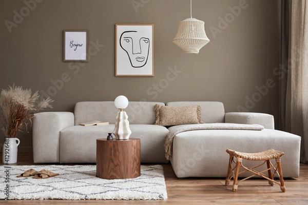 Fototapeta Interior design of stylish living room with modern neutral sofa, mock up poster farmes, dried flowers in vase, coffee tables, decoration and elegant personal accessories in home decor. Template.