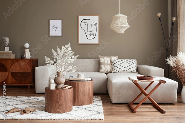 Fototapeta Interior design of stylish living room with modern neutral sofa, furniture, mock up poster farmes, dried flowers in vase, coffee tables, decoration and elegant personal accessories in home decor.