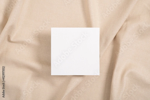 Fototapeta White square invitation card mockup on beige textile background