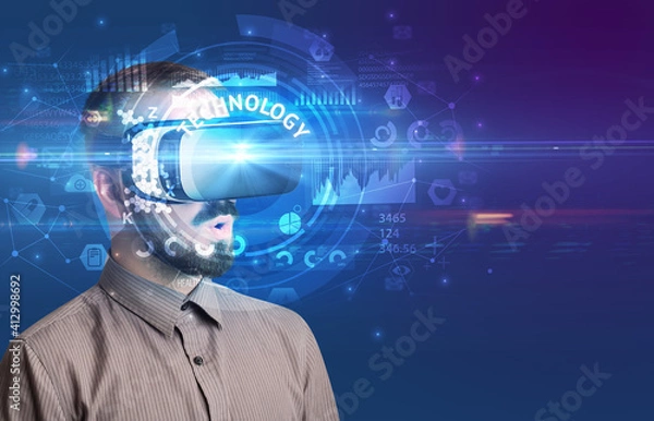 Fototapeta Businessman looking through Virtual Reality glasses with TECHNOLOGY inscription, innovative technology concept