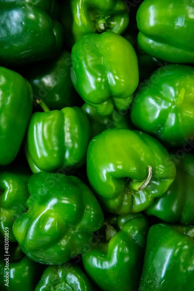Fototapeta Vibrant peppers stacked in a container at a food market