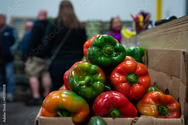 Fototapeta Vibrant peppers stacked in a container at a food market