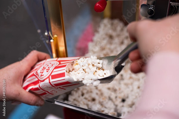 Fototapeta Scooping popcorn into a bag from a popcorn machine