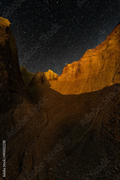 Obraz Canyon with a starry sky at night with a moonlit section.