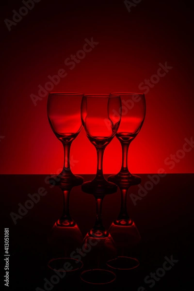 Obraz Empty wine glasses with red background