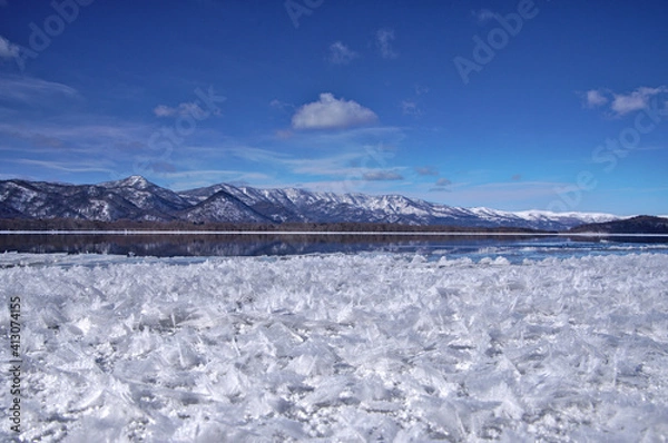Fototapeta 冬の湖のフロストフラワーと白銀の山脈。北海道の屈斜路湖。