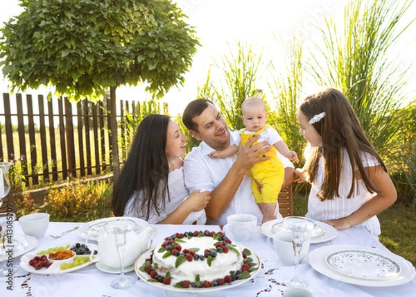 Fototapeta happy family at their backyard having picnic and tea party, hugging, family values