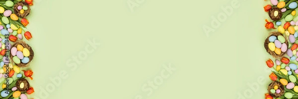 Fototapeta Stylish background with colorful easter eggs pastel colors isolated on green background. Horizontal long banner for web design. Flat lay, top view, mockup, overhead, template