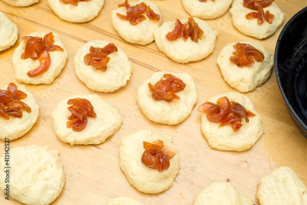 Fototapeta on a wooden table blanks with dough with jam for making buns, pies, donuts Cooking process with yeast dough with filling, close-up, top view