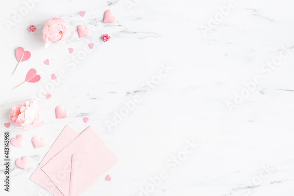 Fototapeta Valentine's Day background. Pink flowers, envelope, hearts on marble background. Valentines day concept. Flat lay, top view