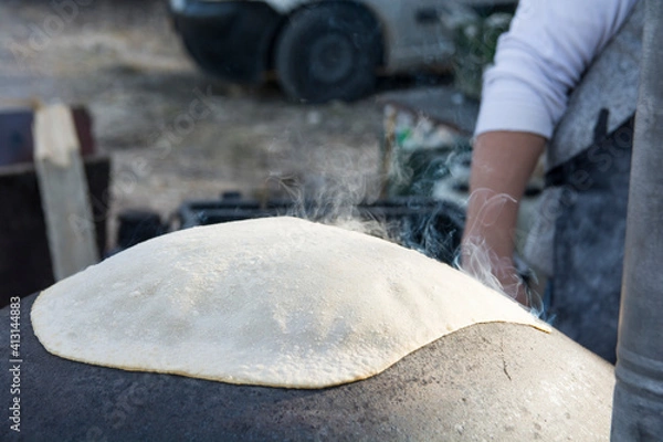 Fototapeta Traditional Druze Pita bread, baked on a Saj or Tava, on open fire
